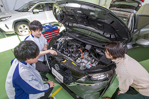 ボンネットを開けて構造を確認する若手社員たち